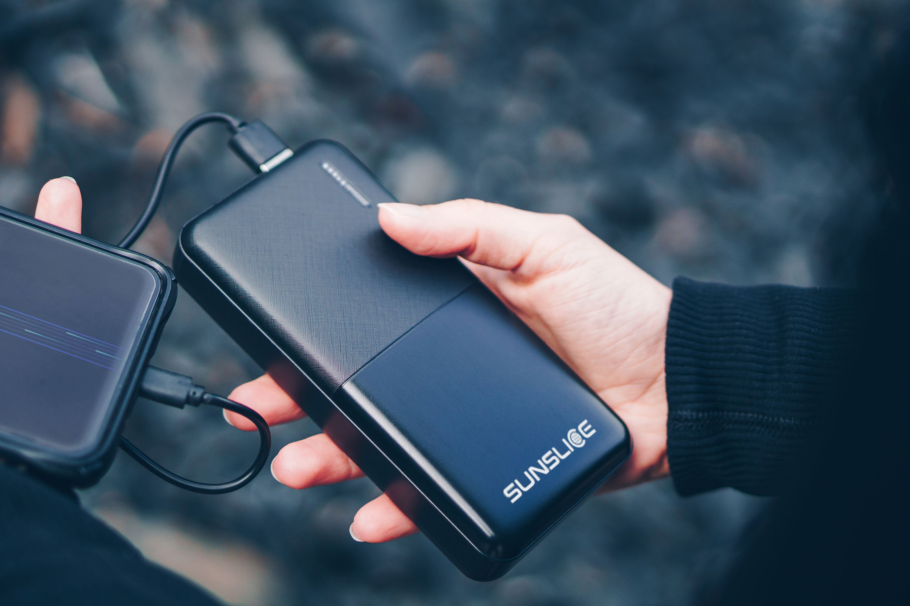 Beautifull power bank connected to a smartphone holding by a woman