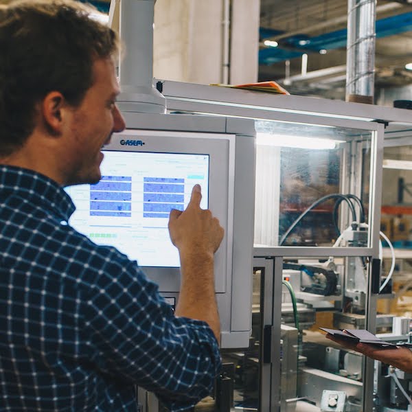Geoffroy Ghion, fondateur de Sunslice effectue des réglages sur la machine de production de panneaux solaires