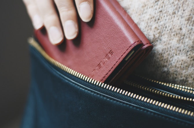 hand of a woman putting a solar power bank charger in her bag