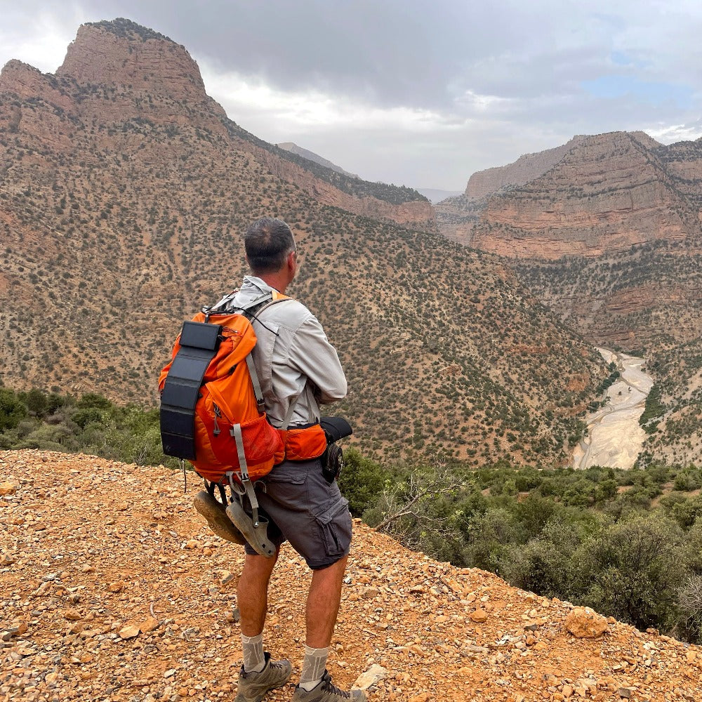 homme vu de dos sur une montagne avec un sac de randonnée et l'Electron