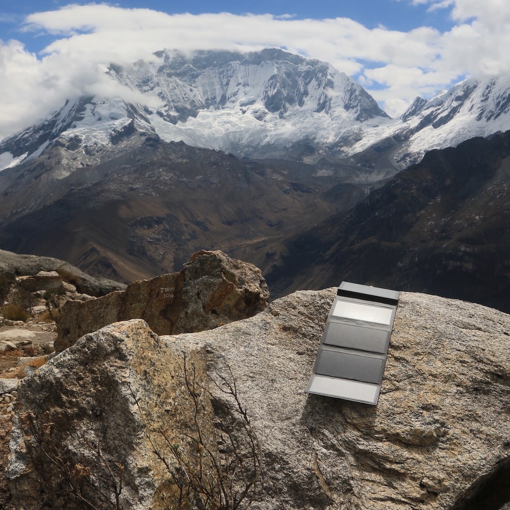 Electron placé sur une pierre au sommet d'une montagne sous un ciel nuageux