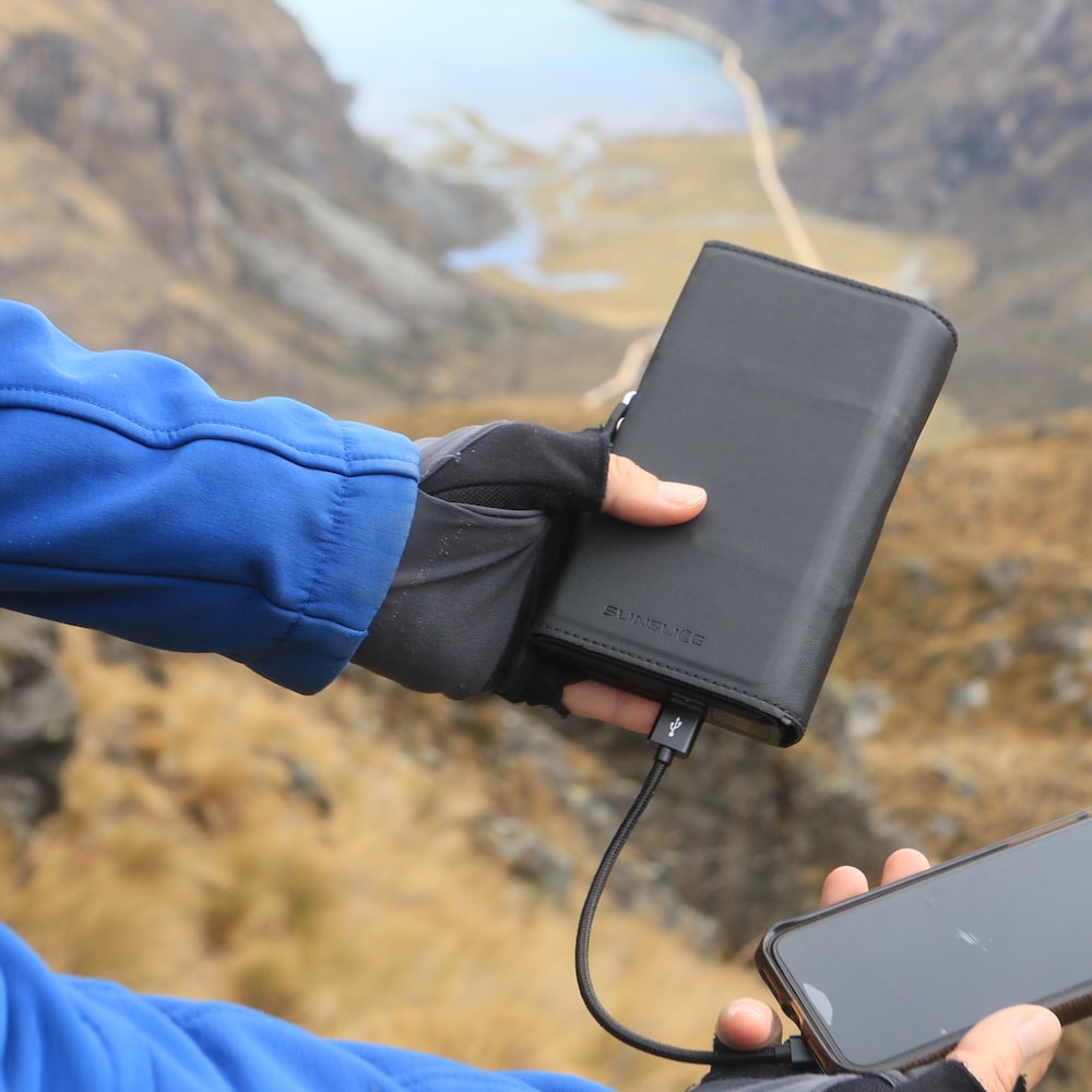 a hand showing a smartphone charged with an electron powerbank