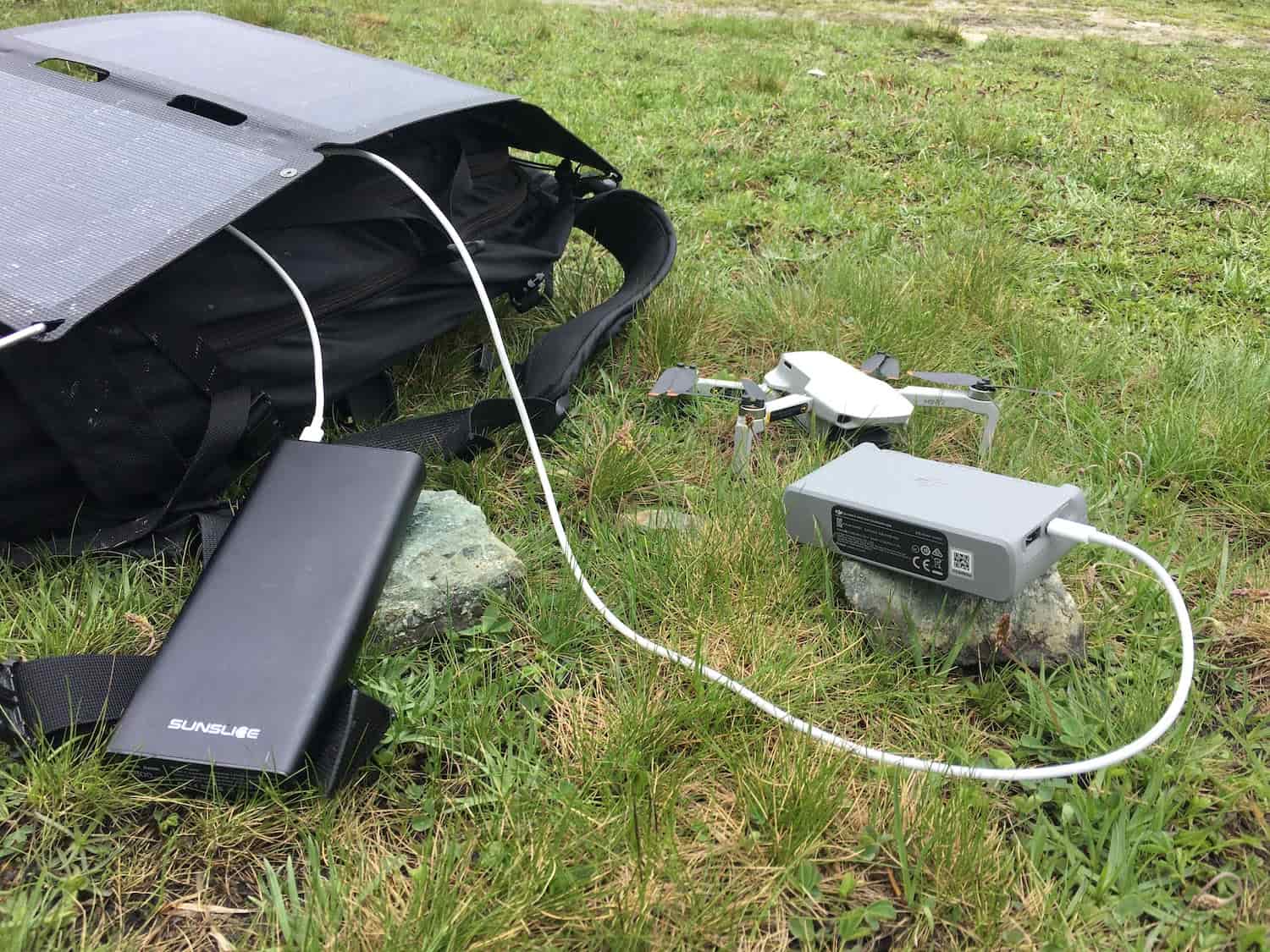 hiking solar panels in the sun charging a 100 watt hour power bank and a drone charger