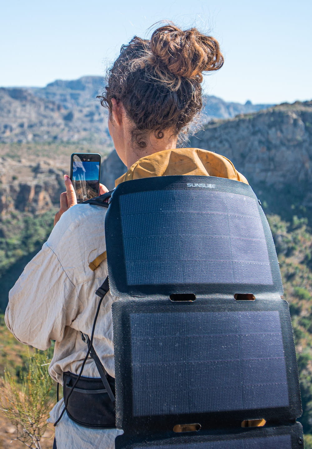 Sunslice Fusion Flex 12 Watt portable solar panel charging a phone in Madagascar