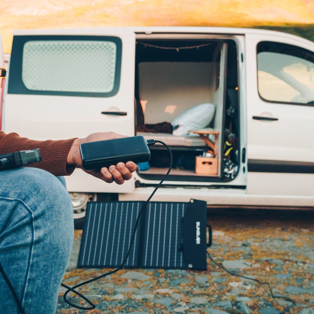 photo taken outside with a man plugging in his solar panel battery