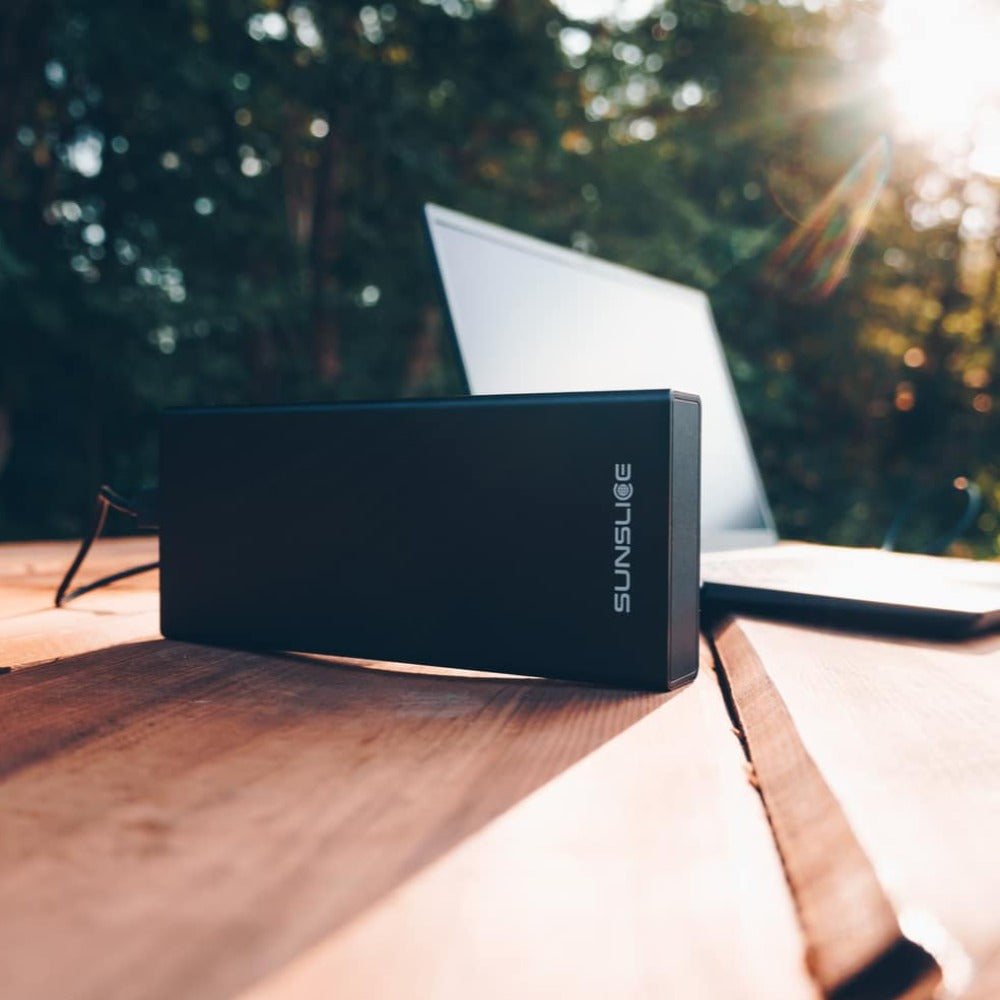 100-Wattstunden-Powerbank zum Aufladen eines Computers auf einem Tisch im Freien