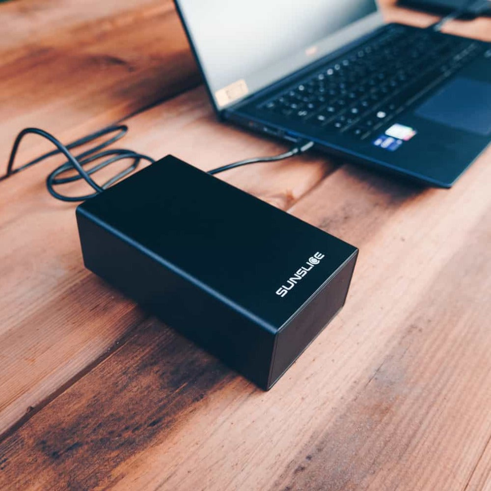 tragbares Laptop-Ladegerät, das einen Computer auf einem Tisch im Freien auflädt