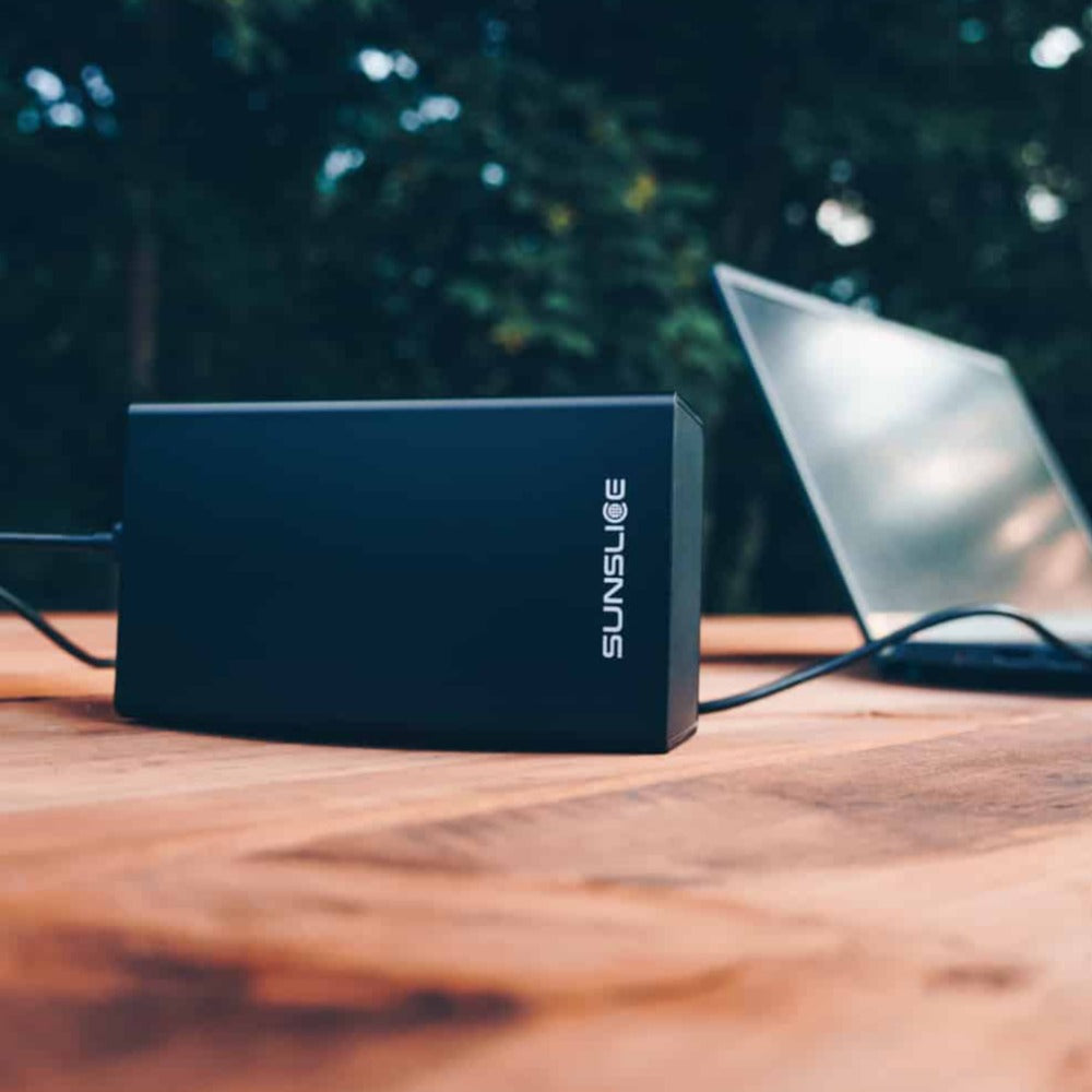 100-Wattstunden-Powerbank zum Aufladen eines Computers auf einem Tisch im Freien