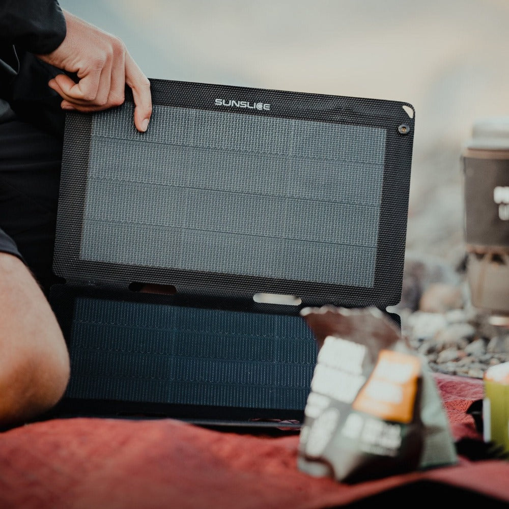man carrying the best portable solar panel on a mountain