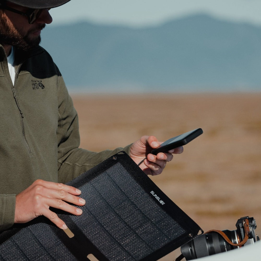 Foto im Freien mit einem Mann, der seine Solarmodul-Batterie einsteckt