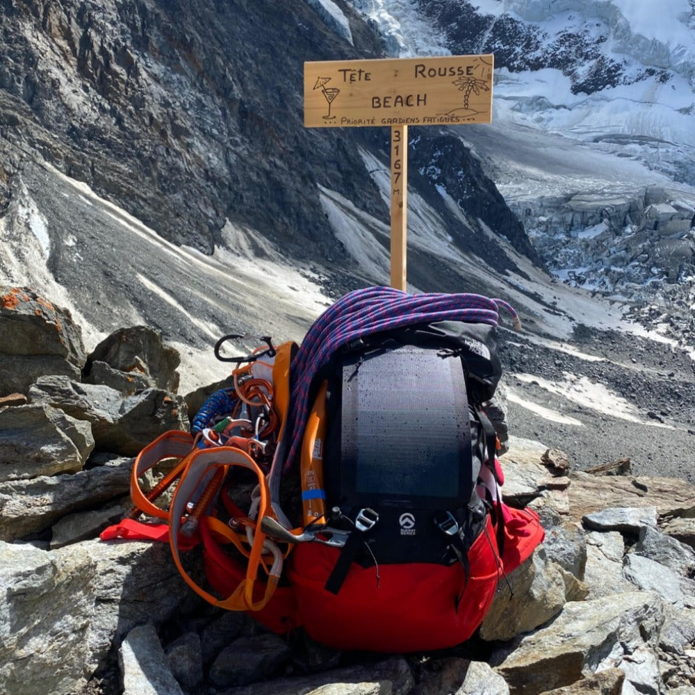randonnée en montagne avec des panneaux solaires sur un sac à dos