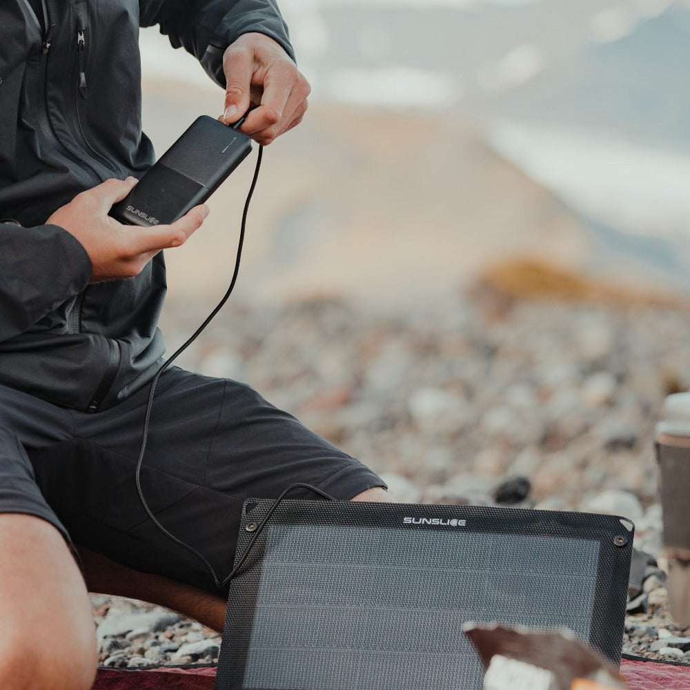 photo prise à l'extérieur avec un homme qui branche la batterie de son panneau solaire