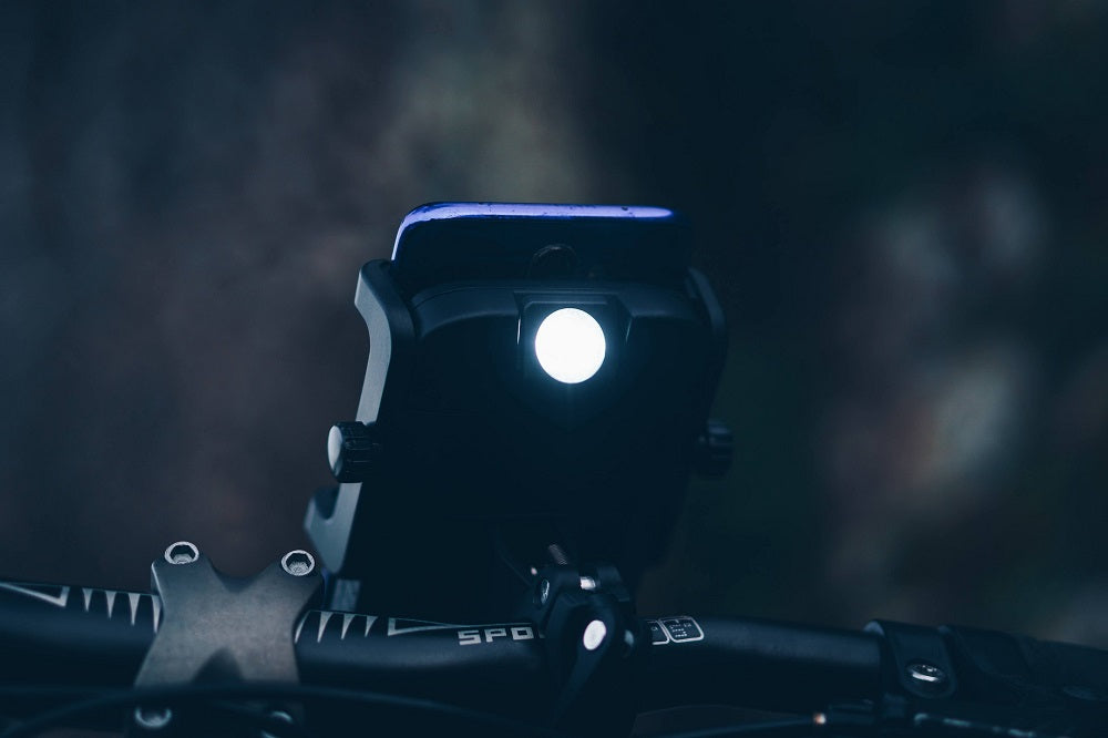 Photo d'un Cyclotron monté sur un guidon, prise au milieu de la nuit avec sa lampe de poche allumée.
