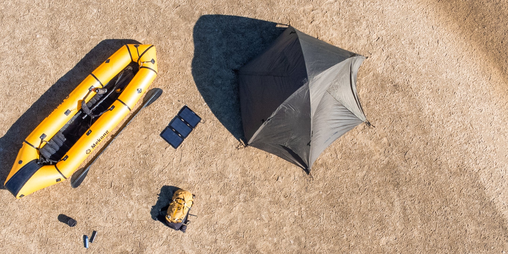 Panneau solaire de 18 watts à côté d'un radeau et d'une tente pour la randonnée 