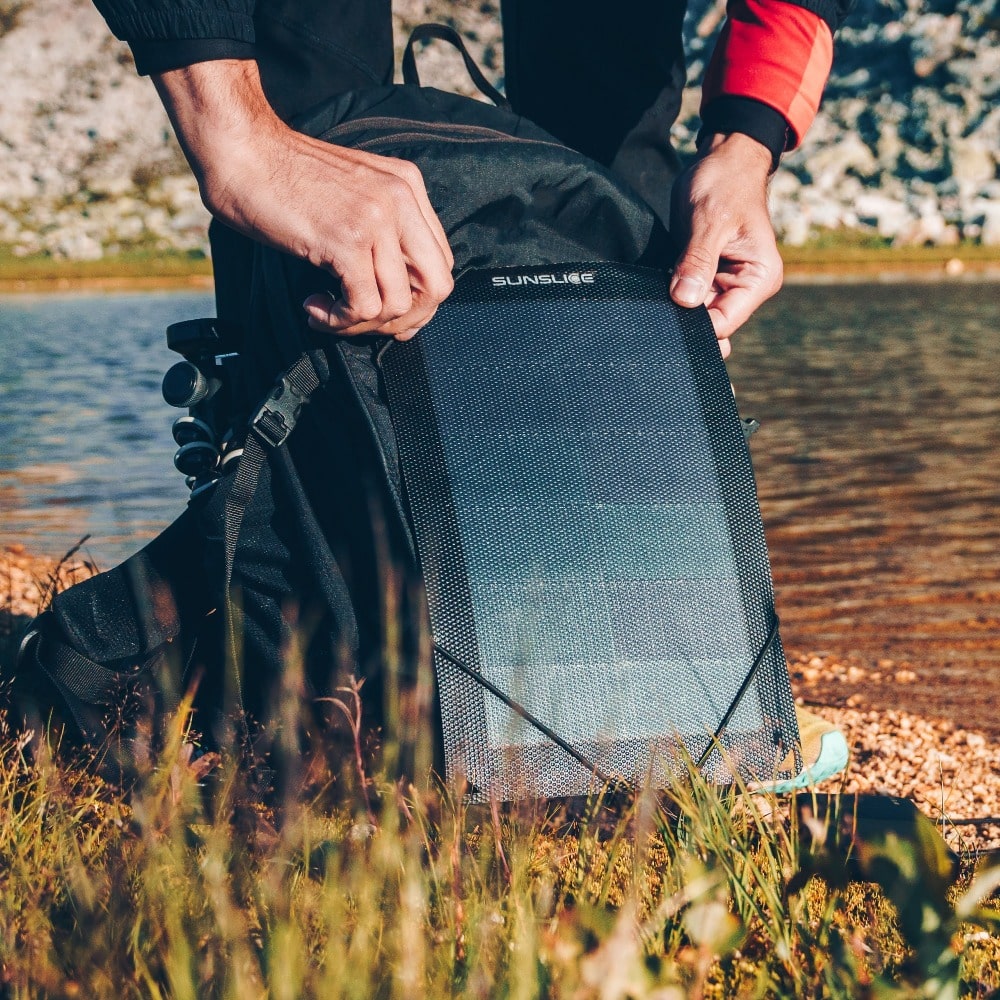 sac à dos de randonnée avec panneau solaire pour campeur au bord de la rivière