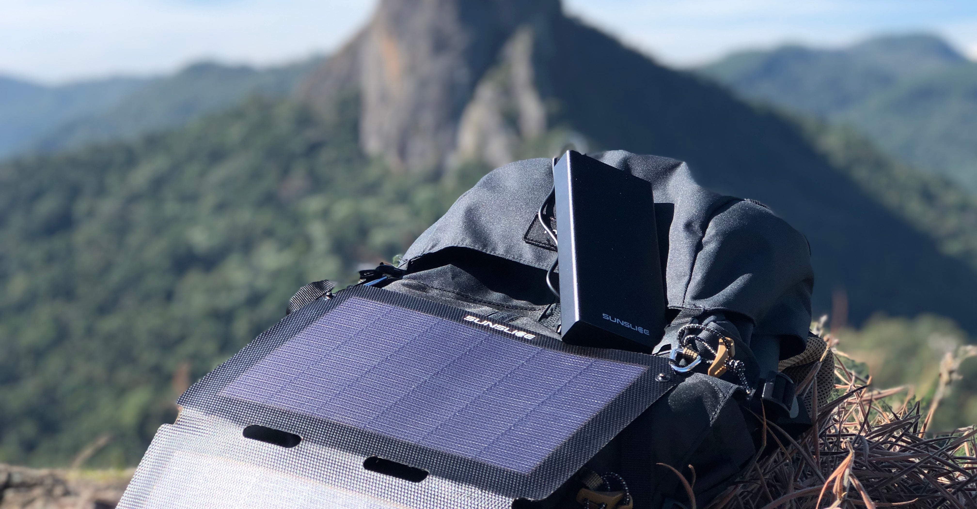 view of a sunny mountain with a portable solar panel connected to a power bank 20000mah