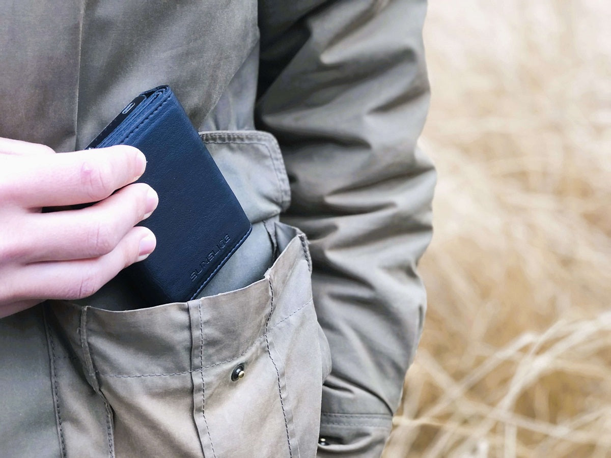 man's hand slipping a black portable solar charger into his pocket