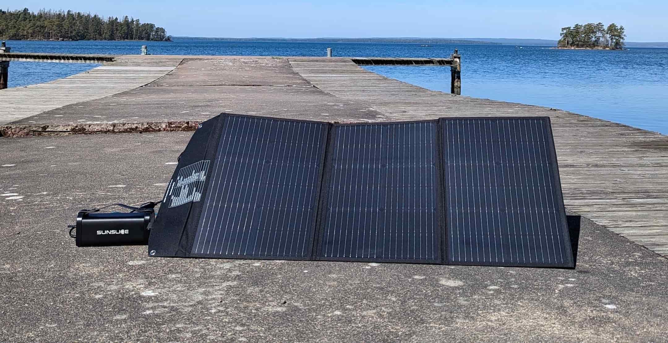 a solar power pack on a kind of walkway at the water's edge on a very sunny day