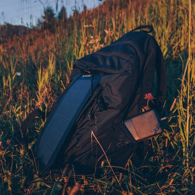 panneau solaire portable pour le camping connecté à une batterie externe sur un sac à dos