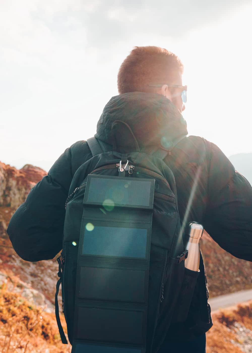 Sunslice's newest solar power bank, the Electron, charging in the sun on a backpack during hiking