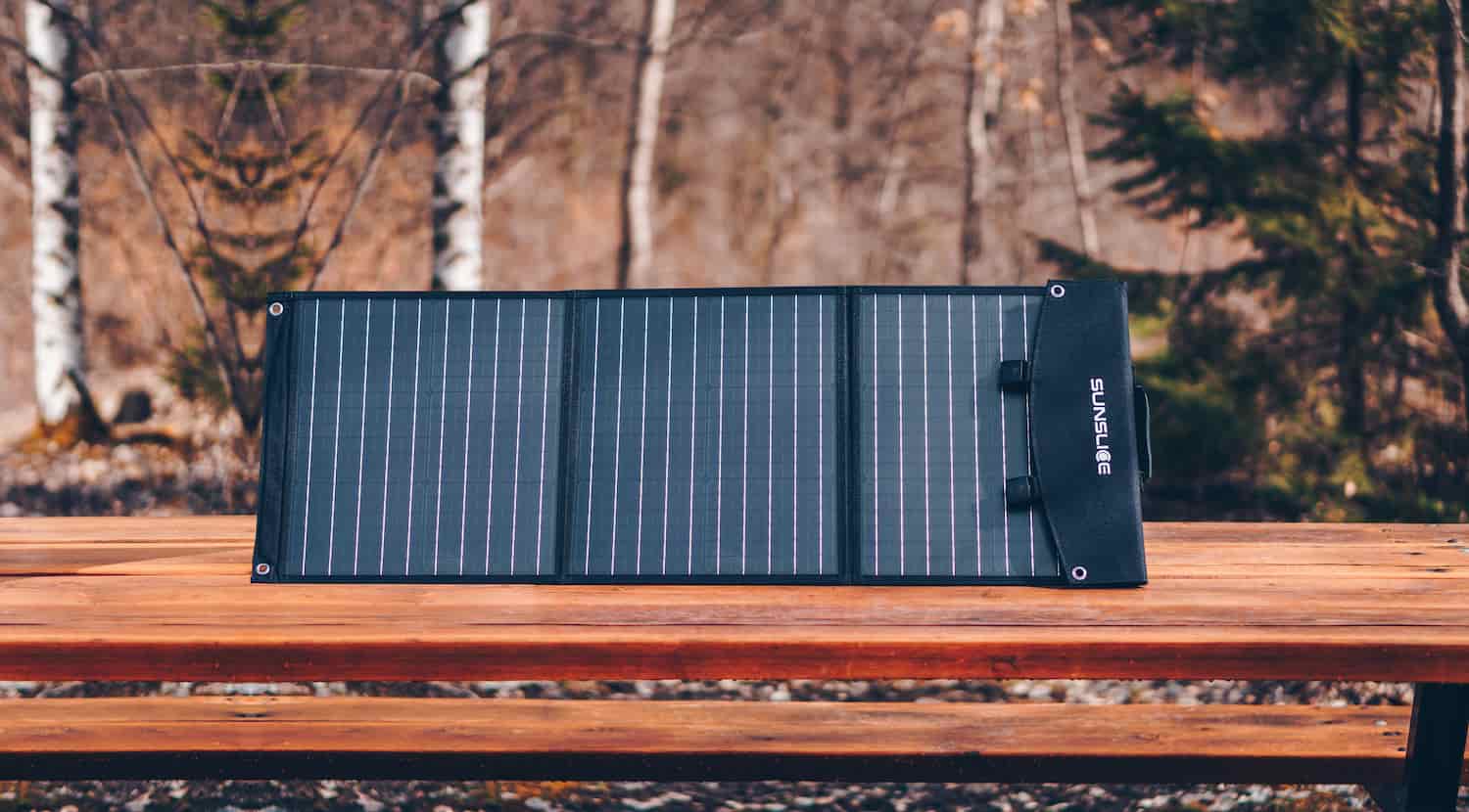 tragbares Solarpanel für Camping auf einem Tisch mitten im Wald