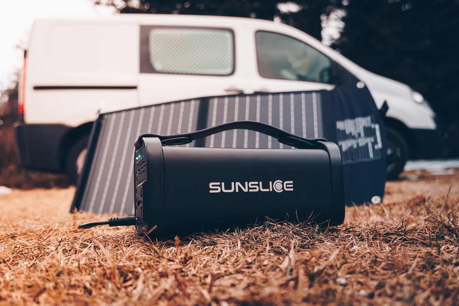 opvouwbaar zonnepaneel met zijn zonnepaneelbatterij met een auto als onscherpe achtergrond