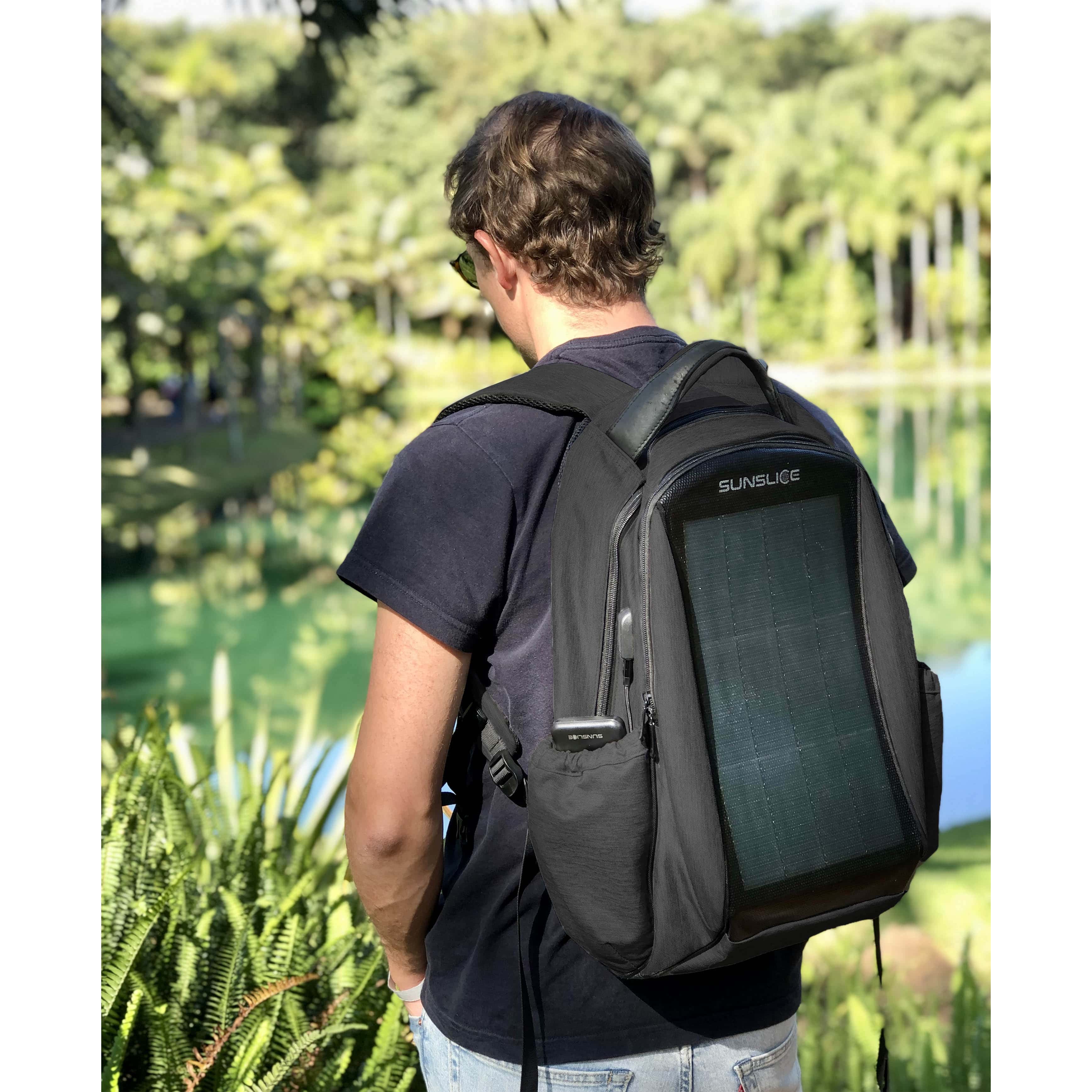 Man looking at a lake with a solar backpack on his back ( Sunslice Zenit in black)