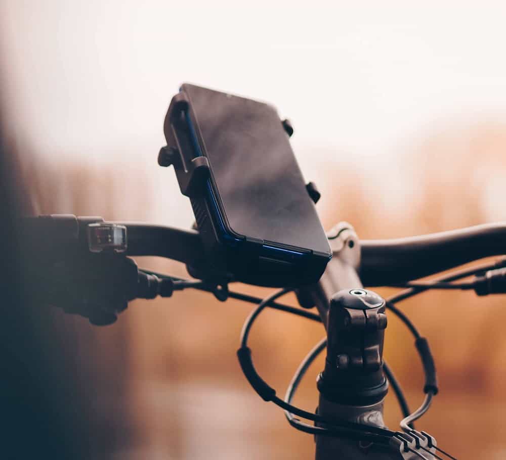 smartphone op een telefoonhouder voor motorfiets met wazige oranje achtergrond