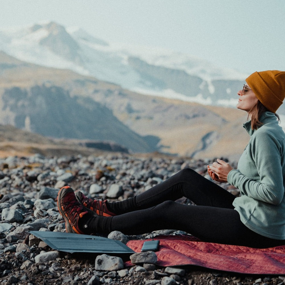 woman taking a rest on a mountain with her solar charger