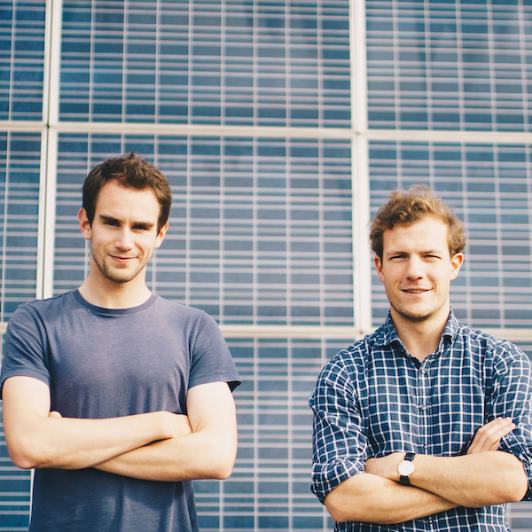 Sunslice founders Henri Gernaey and Geoffroy Ghion in front of a large solar panel