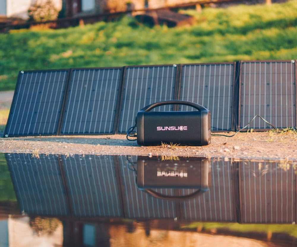 panneau solaire portable pour le camping sur l'herbe verte avec à côté un générateur solaire pour la maison