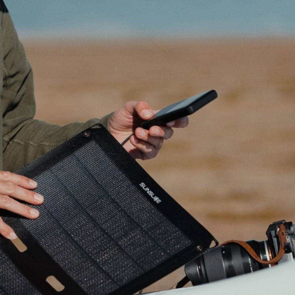 Foto im Freien mit einem Mann, der seine Solarmodul-Batterie einsteckt