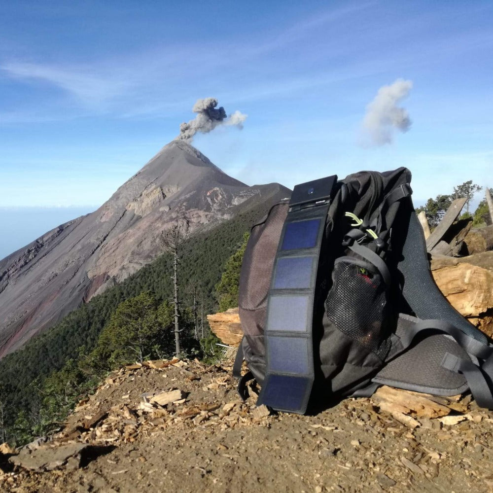 Photon - photo avec comme arrière-plan un volcan au Guatemala et un sac de randonnée avec le meilleur chargeur solaire pour téléphone le Photon